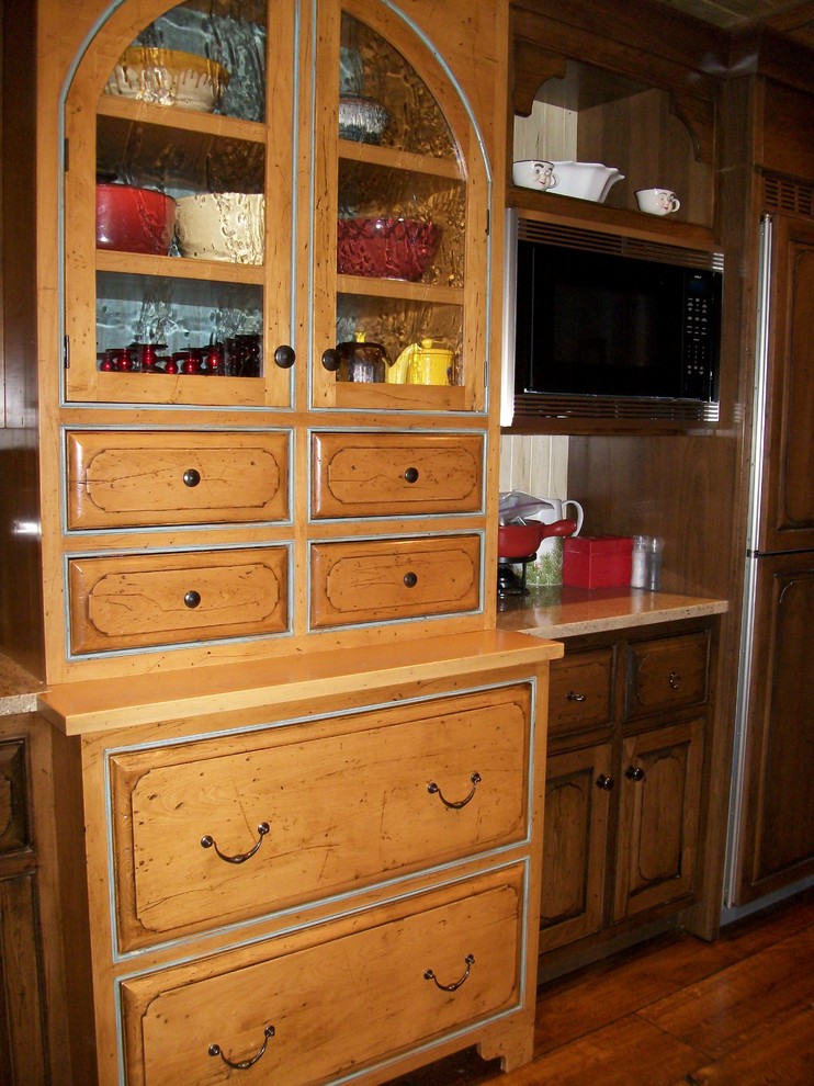 Inspiration for a large rustic l-shaped medium tone wood floor eat-in kitchen remodel in New York with an undermount sink, raised-panel cabinets, distressed cabinets, quartz countertops, paneled appliances and an island