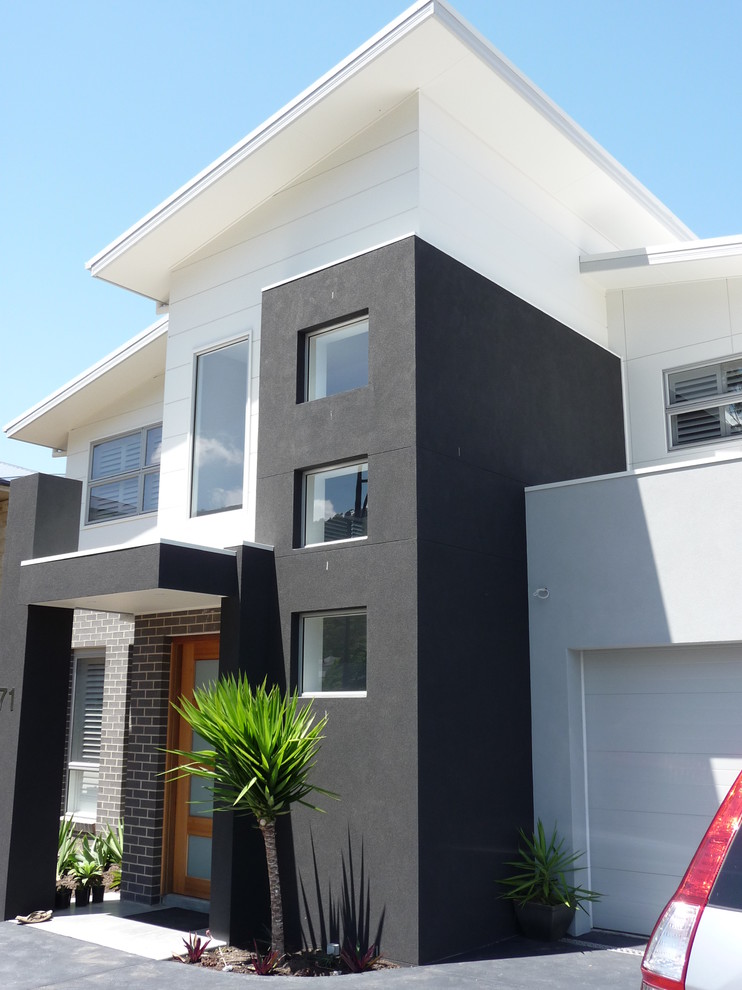 Photo of a large beach style two-storey white exterior in Wollongong with mixed siding.