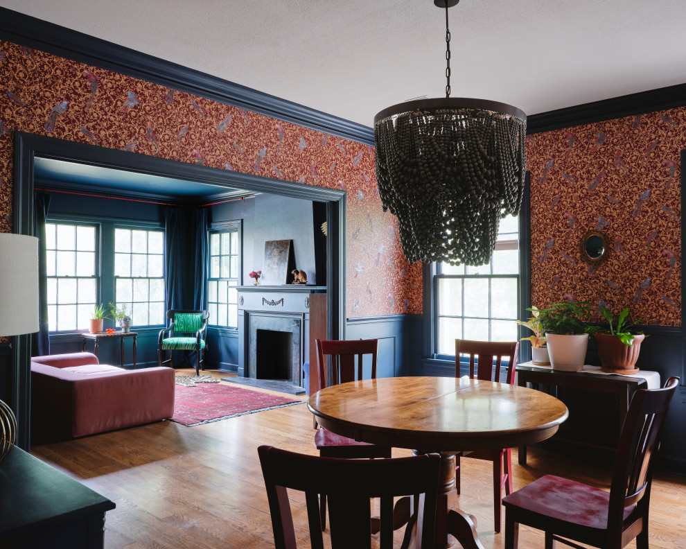 Ejemplo de comedor ecléctico de tamaño medio abierto con paredes multicolor, suelo de madera en tonos medios, todas las chimeneas y panelado