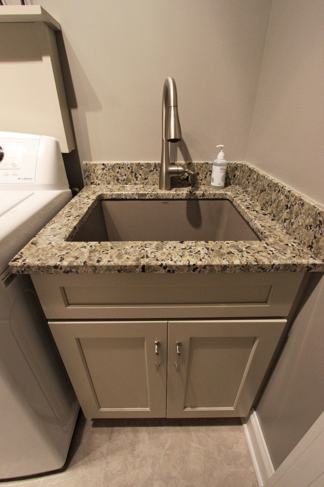 Inspiration for a small transitional single-wall dedicated laundry room in Cleveland with an undermount sink, flat-panel cabinets, beige cabinets, granite benchtops, beige walls, vinyl floors, a side-by-side washer and dryer, beige floor and beige benchtop.