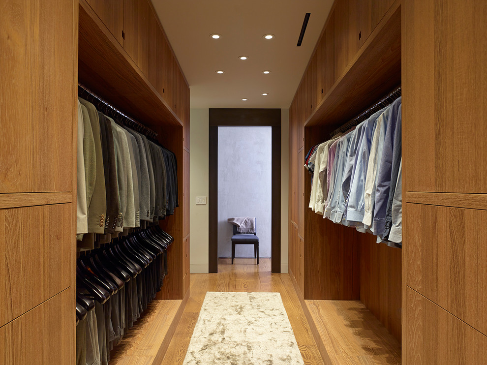 Large contemporary men's walk-in wardrobe in New York with open cabinets, medium wood cabinets, medium hardwood floors and brown floor.
