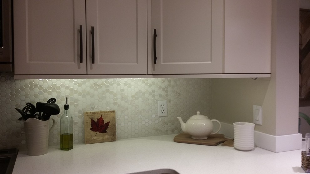 Eat-in kitchen - mid-sized transitional u-shaped dark wood floor and brown floor eat-in kitchen idea with an undermount sink, shaker cabinets, white cabinets, quartzite countertops, white backsplash, glass tile backsplash, stainless steel appliances and white countertops
