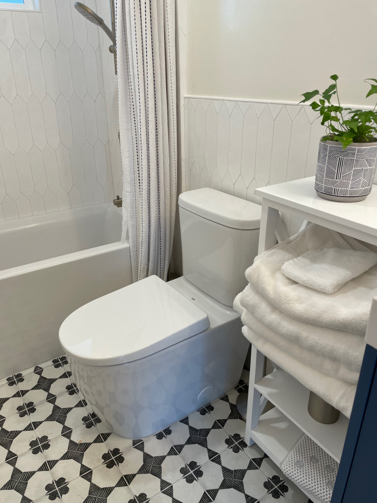 Design ideas for a small contemporary kids bathroom in San Francisco with flat-panel cabinets, blue cabinets, an alcove tub, a shower/bathtub combo, a two-piece toilet, yellow tile, ceramic tile, white walls, cement tiles, an integrated sink, engineered quartz benchtops, multi-coloured floor, a shower curtain, yellow benchtops, a niche, a single vanity and a floating vanity.