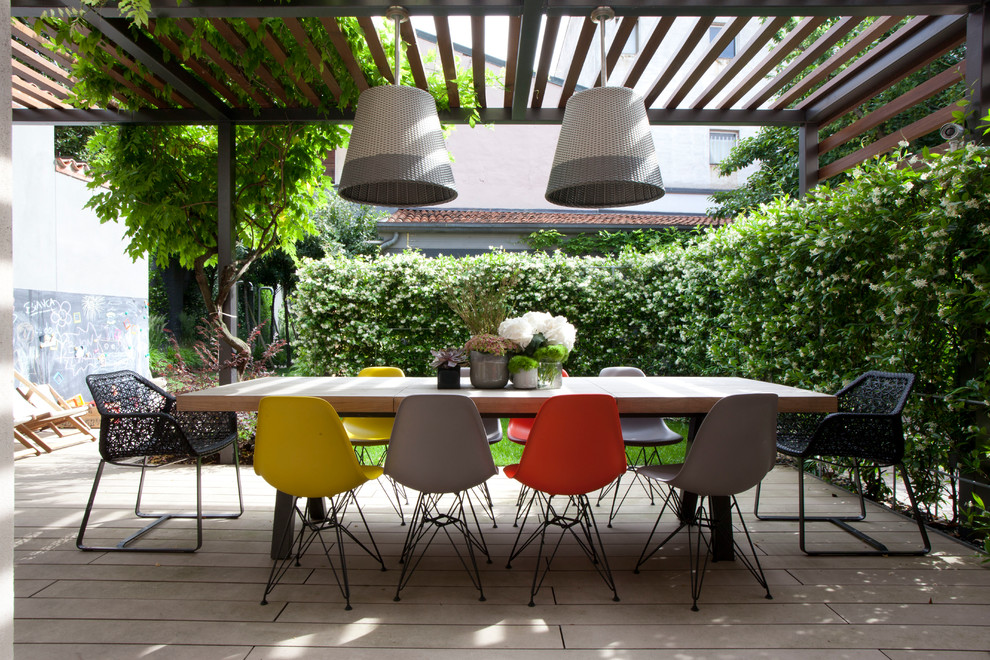 Photo of a contemporary backyard patio in Milan with a pergola.