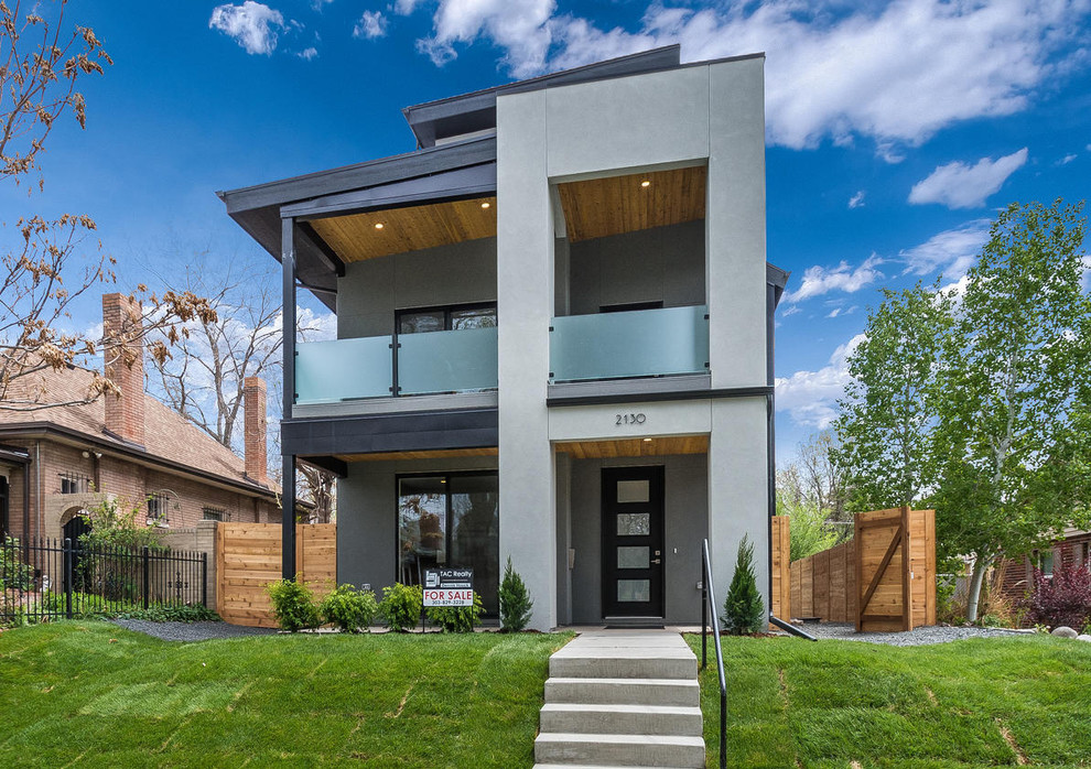 Photo of a mid-sized modern two-storey stucco grey house exterior in Denver with a flat roof and a green roof.
