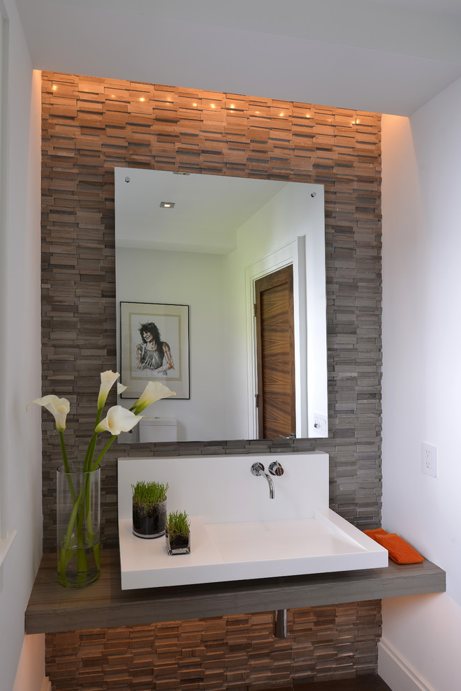 Photo of a modern powder room in New York with white walls and gray tile.