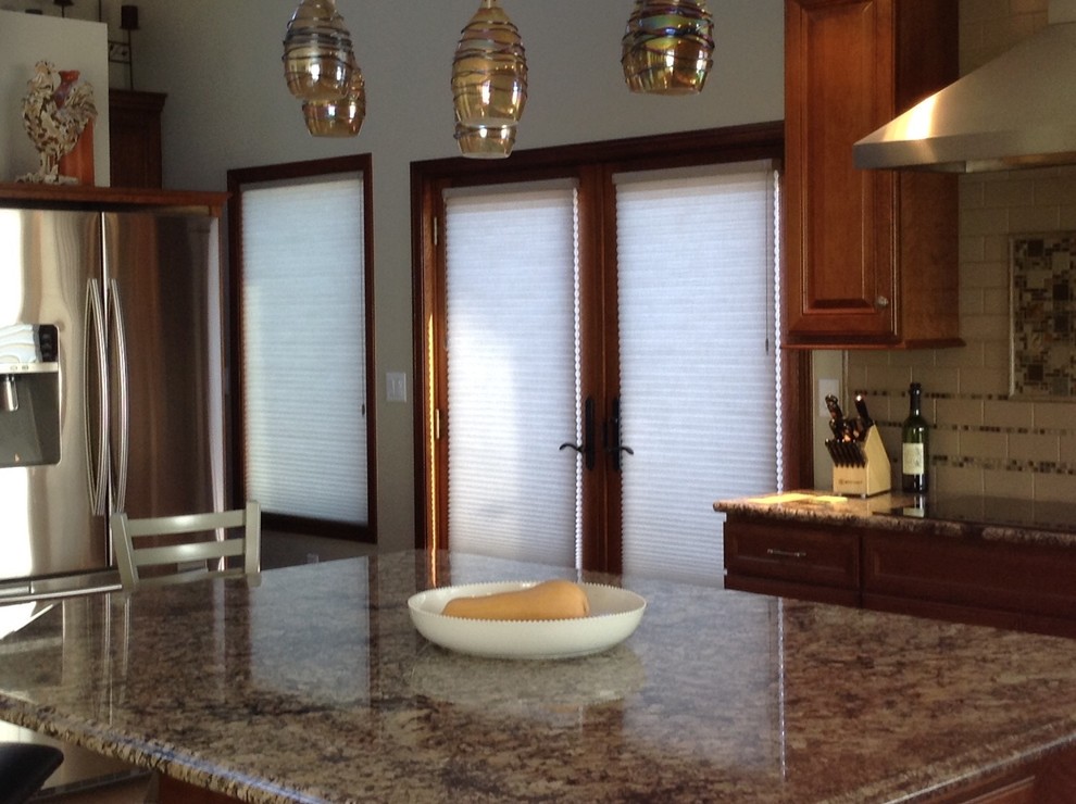 Inspiration for a mid-sized transitional single-wall kitchen pantry remodel in Seattle with raised-panel cabinets, medium tone wood cabinets, granite countertops, beige backsplash, ceramic backsplash, stainless steel appliances and an island