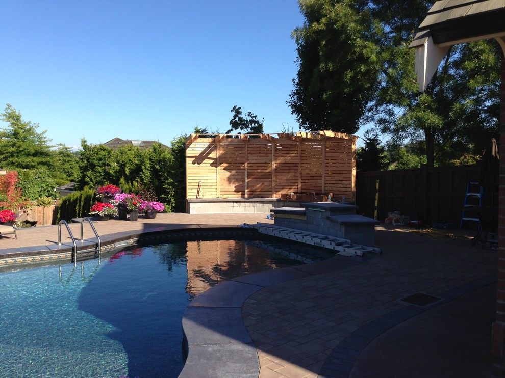 Pool fountain - mid-sized transitional backyard brick and custom-shaped lap pool fountain idea in Vancouver