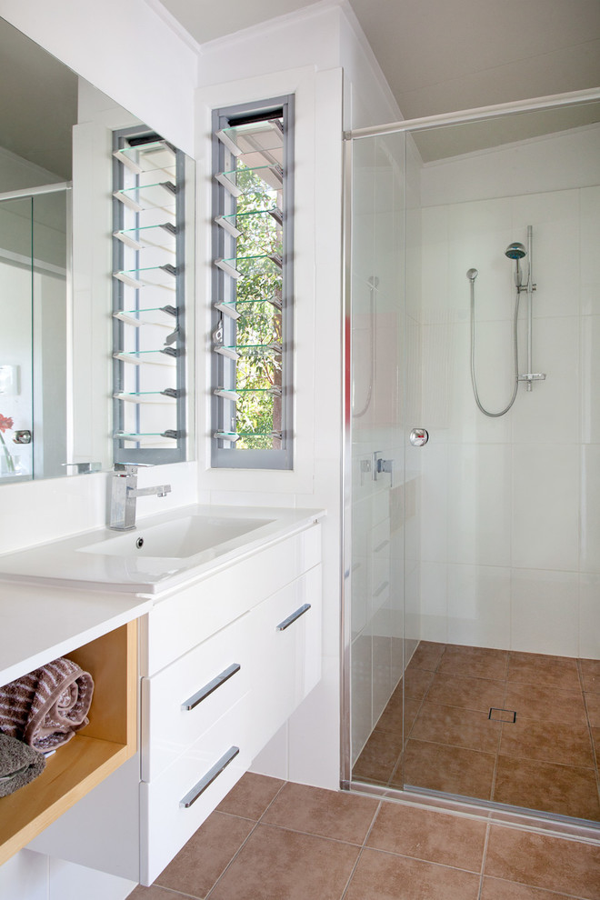 Design ideas for a contemporary bathroom in Brisbane with flat-panel cabinets and white cabinets.