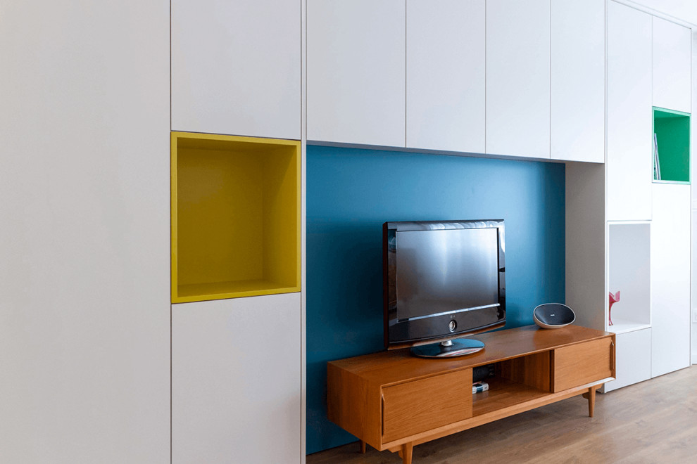 Idéer för funkis allrum med öppen planlösning, med blå väggar, mellanmörkt trägolv, en fristående TV och brunt golv