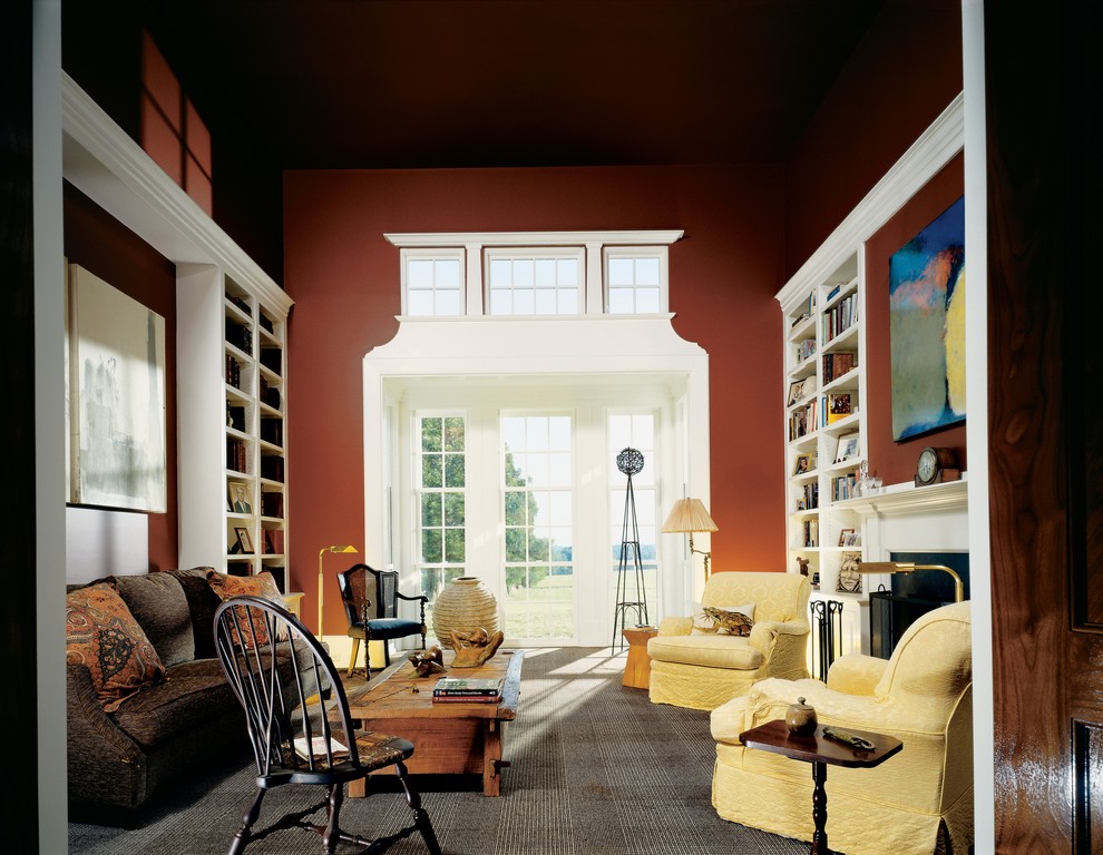 Photo of a country living room in Richmond with red walls and a library.