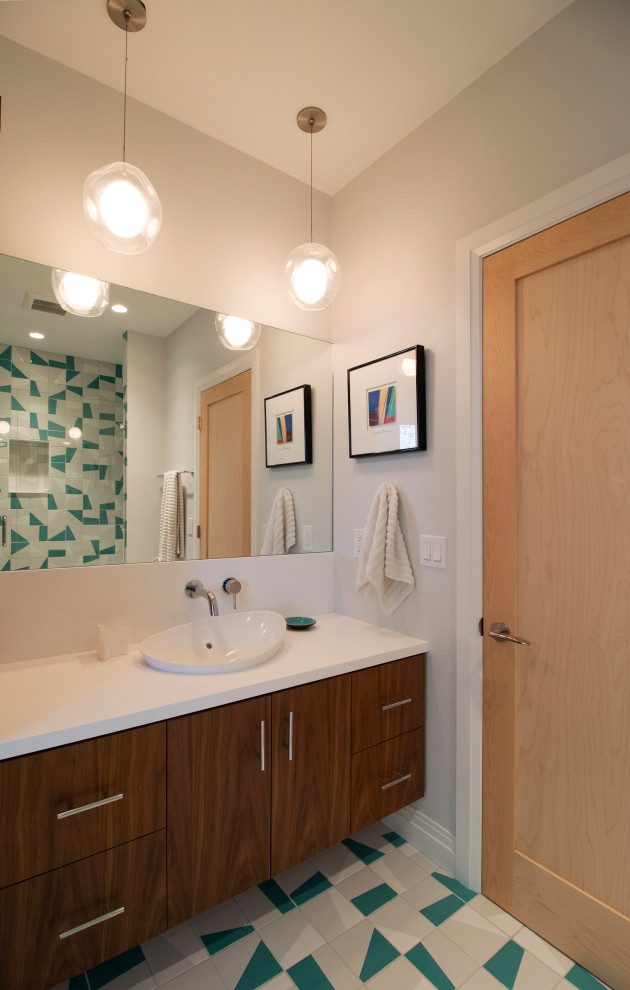 Стильный дизайн: ванная комната среднего размера в стиле модернизм с плоскими фасадами, белыми фасадами, душем в нише, унитазом-моноблоком, белыми стенами, полом из керамогранита, душевой кабиной, настольной раковиной, столешницей из искусственного камня, зеленым полом, душем с распашными дверями, белой столешницей, сиденьем для душа, тумбой под одну раковину и подвесной тумбой - последний тренд