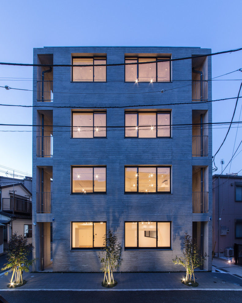 Esempio della facciata di un appartamento ampio grigio moderno a quattro piani con rivestimento in cemento, tetto piano e tetto grigio