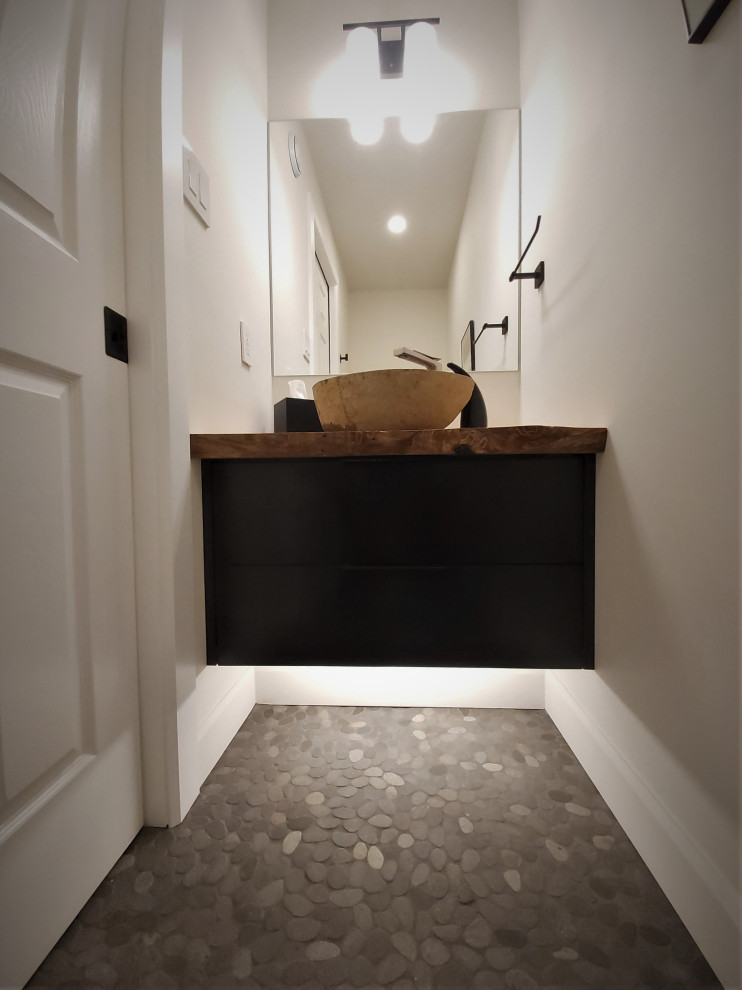 Exempel på ett litet modernt badrum, med släta luckor, svarta skåp, en toalettstol med separat cisternkåpa, vita väggar, klinkergolv i småsten, ett fristående handfat, träbänkskiva och grått golv