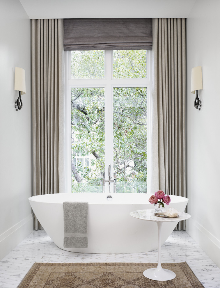 Photo of a transitional master bathroom in Austin with a freestanding tub and grey walls.