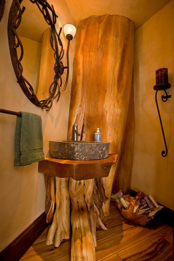Photo of a country powder room in Denver with medium hardwood floors, a vessel sink and wood benchtops.