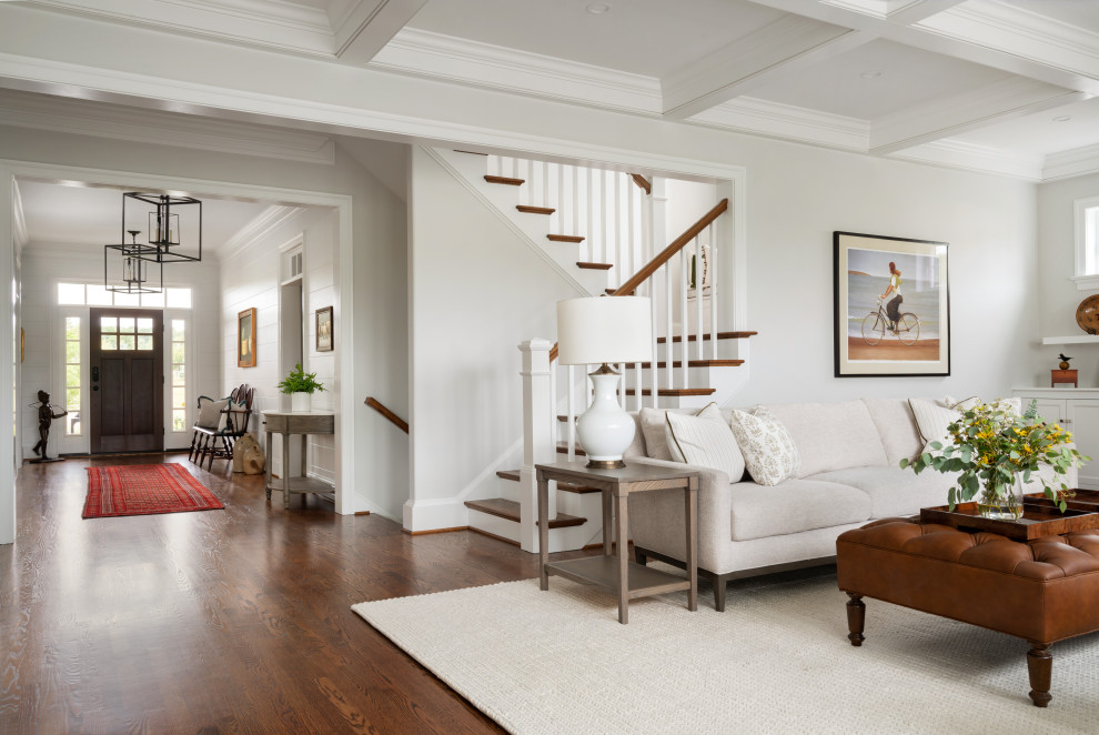 Large transitional open concept living room in Philadelphia with white walls, dark hardwood floors, a wood fireplace surround, a wall-mounted tv, coffered and planked wall panelling.