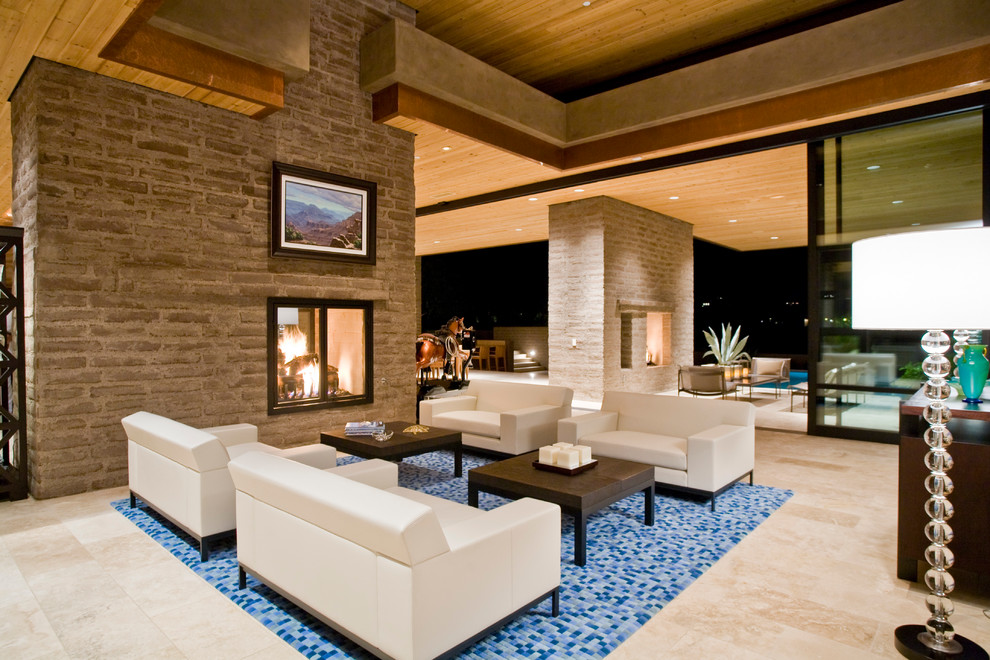 Photo of a modern formal open concept living room in Phoenix with a two-sided fireplace and a brick fireplace surround.