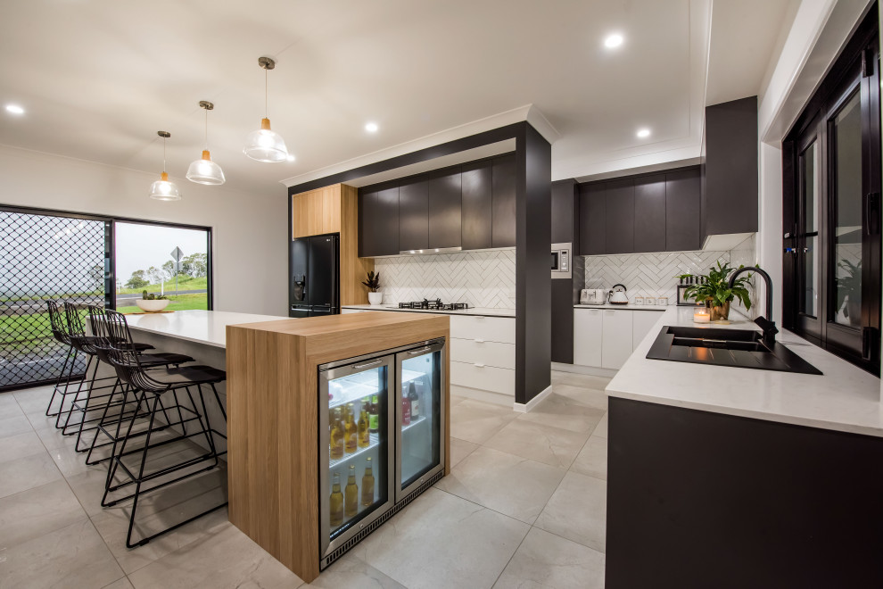 Inspiration for a large contemporary galley kitchen pantry in Other with a drop-in sink, flat-panel cabinets, white cabinets, granite benchtops, white splashback, subway tile splashback, black appliances, ceramic floors, with island, grey floor and white benchtop.