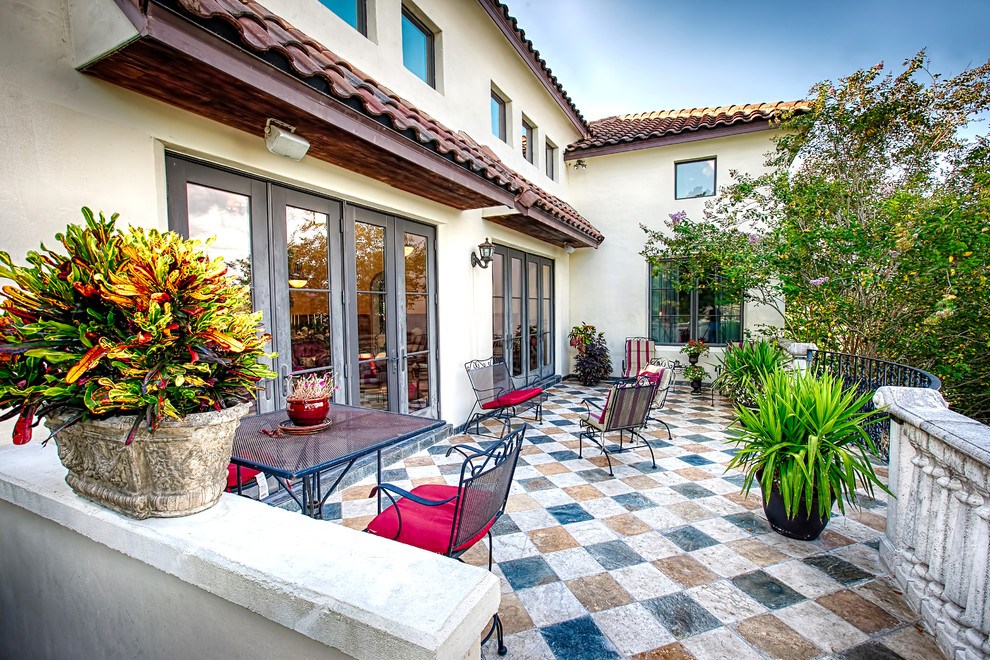 This is an example of a mediterranean patio in Orlando with tile and no cover.