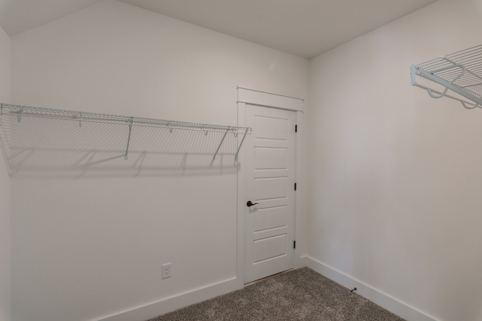 Mid-sized country gender-neutral walk-in wardrobe in Nashville with carpet and grey floor.