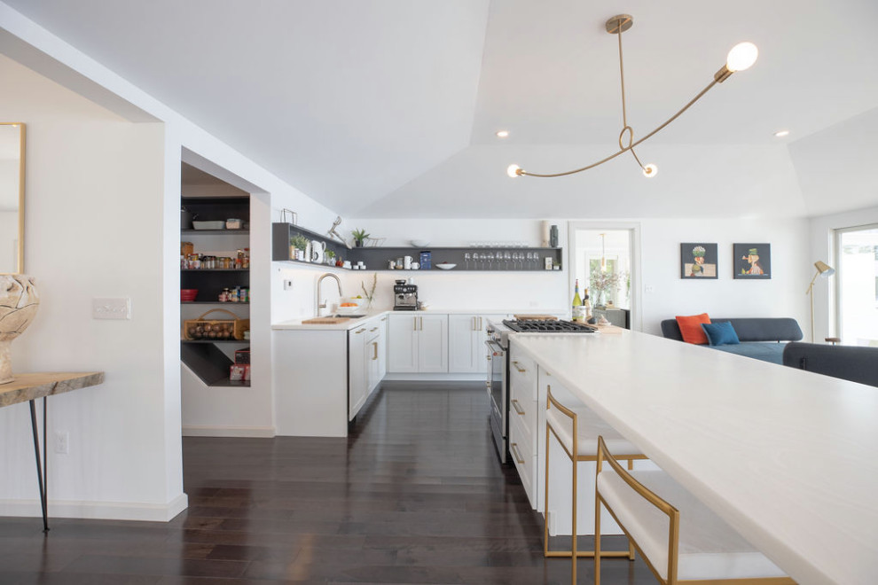Modern inredning av ett mellanstort vit vitt kök, med en undermonterad diskho, luckor med infälld panel, vita skåp, bänkskiva i koppar, rostfria vitvaror, mörkt trägolv, en köksö och grått golv