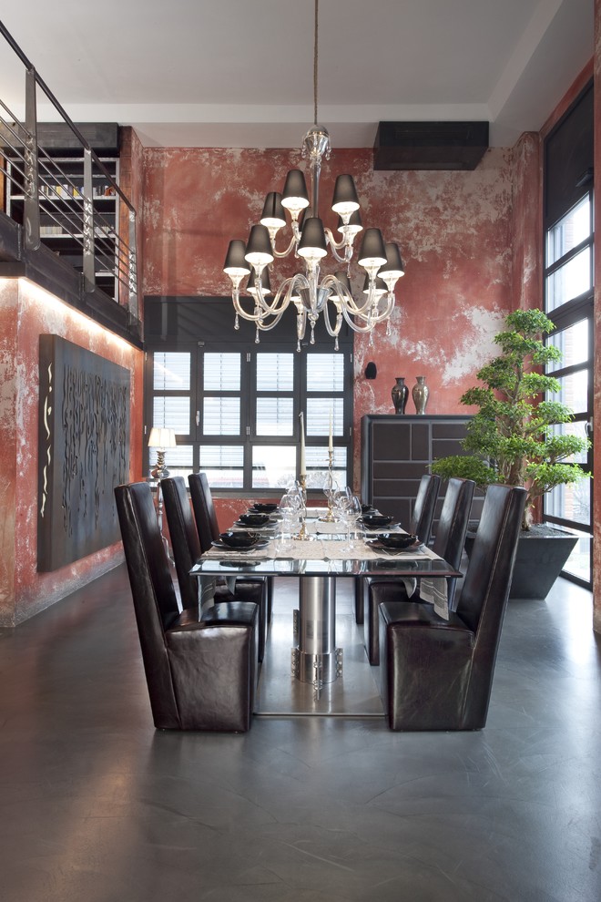 Photo of a large industrial dining room in Milan with concrete floors and red walls.