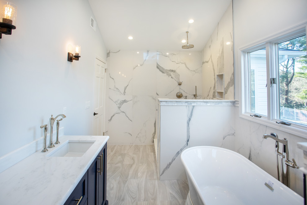 Bild på ett stort funkis vit vitt en-suite badrum, med skåp i shakerstil, blå skåp, ett fristående badkar, en dusch i en alkov, vit kakel, marmorkakel, vita väggar, klinkergolv i keramik, ett undermonterad handfat, bänkskiva i kvarts, vitt golv och med dusch som är öppen