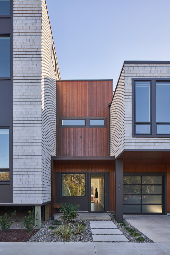 На фото: большой, деревянный, коричневый частный загородный дом в стиле модернизм с разными уровнями, плоской крышей и отделкой дранкой с