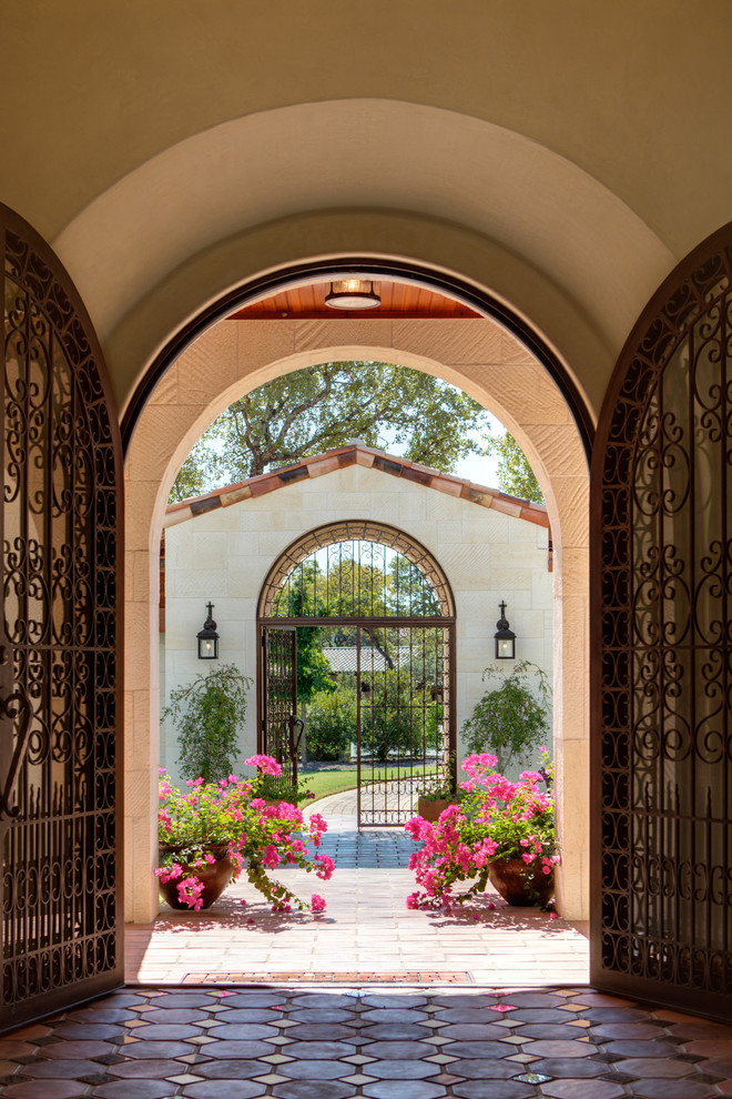 This is an example of a mediterranean entryway in Austin with a double front door and a metal front door.