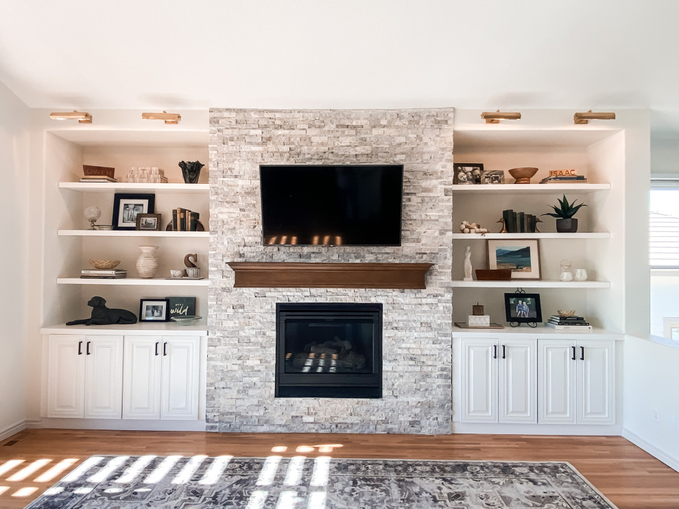 Photo of a mid-sized transitional living room in Denver with white walls, medium hardwood floors, a standard fireplace and a built-in media wall.