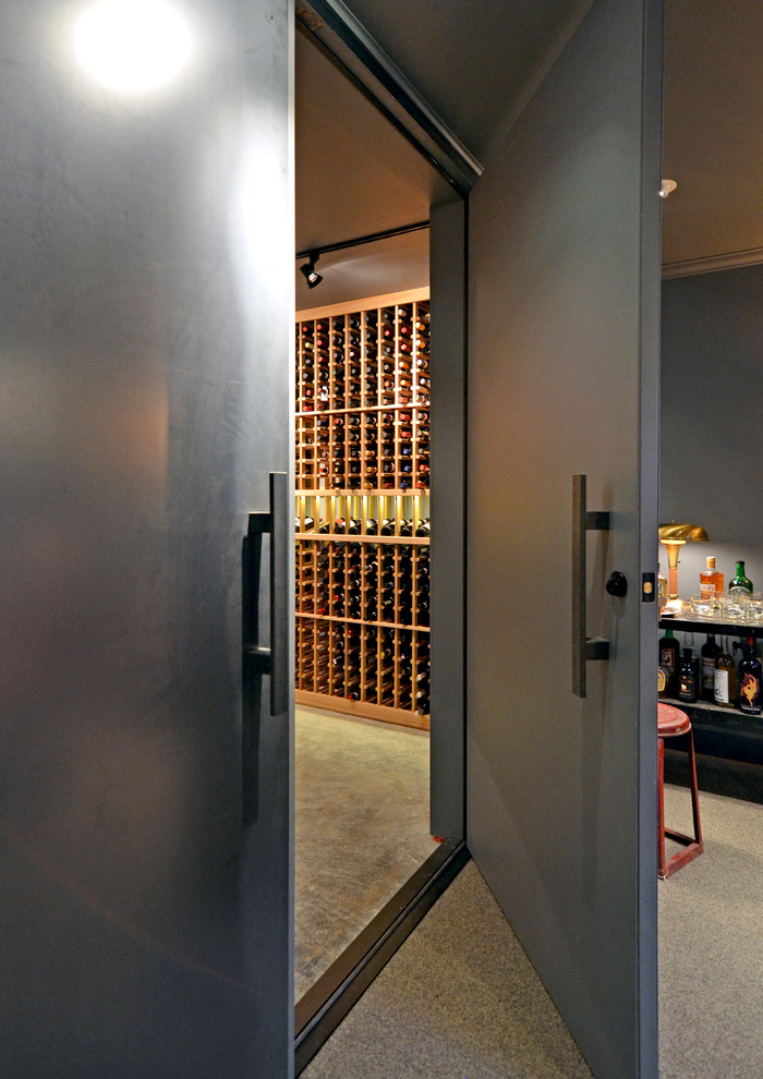 This is an example of a large industrial wine cellar in Seattle with concrete floors and storage racks.