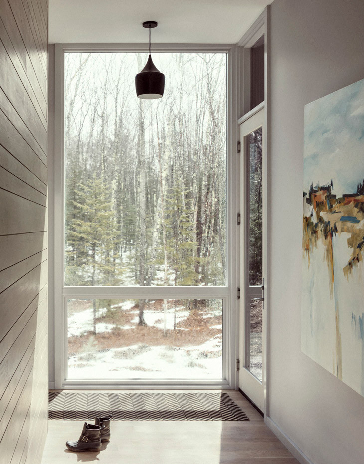 Ispirazione per un ingresso o corridoio minimalista con pavimento in legno massello medio e pareti in perlinato