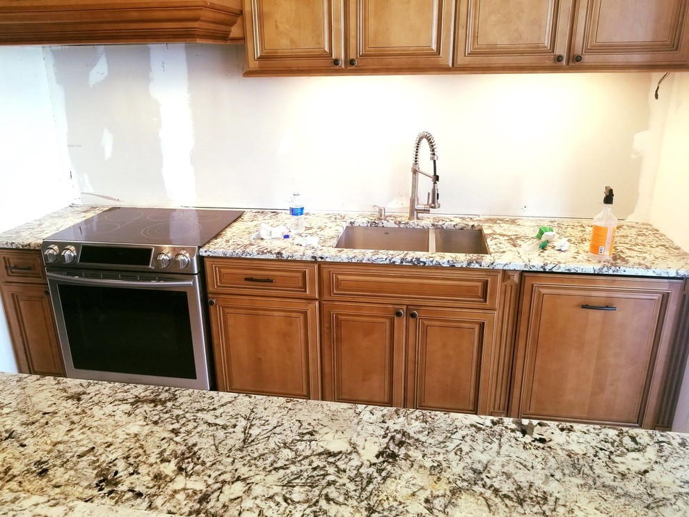 This is an example of a mid-sized modern single-wall kitchen pantry in Tampa with a double-bowl sink, granite benchtops and with island.