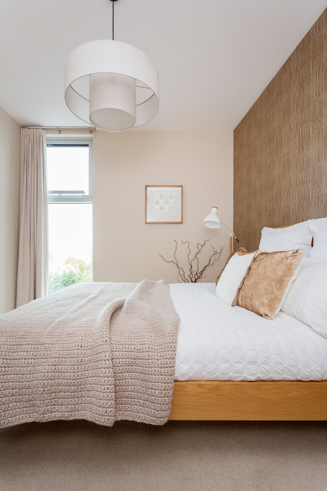 Inspiration for a contemporary bedroom in London with beige walls, carpet and beige floor.