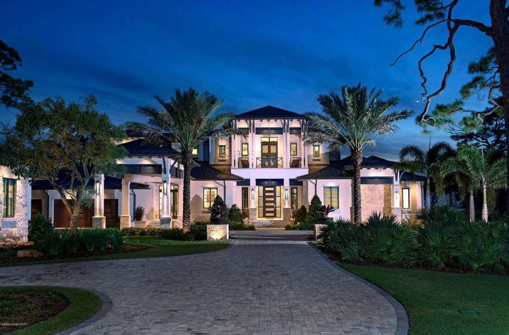 Design ideas for an expansive contemporary two-storey concrete beige house exterior in Orlando with a metal roof.