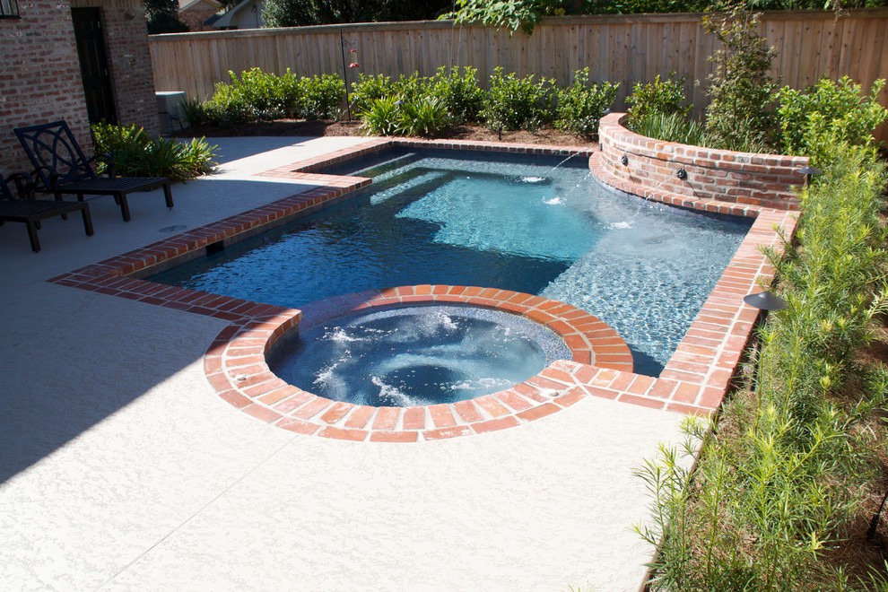 Inspiration for a mid-sized traditional backyard custom-shaped lap pool in New Orleans with a hot tub and brick pavers.