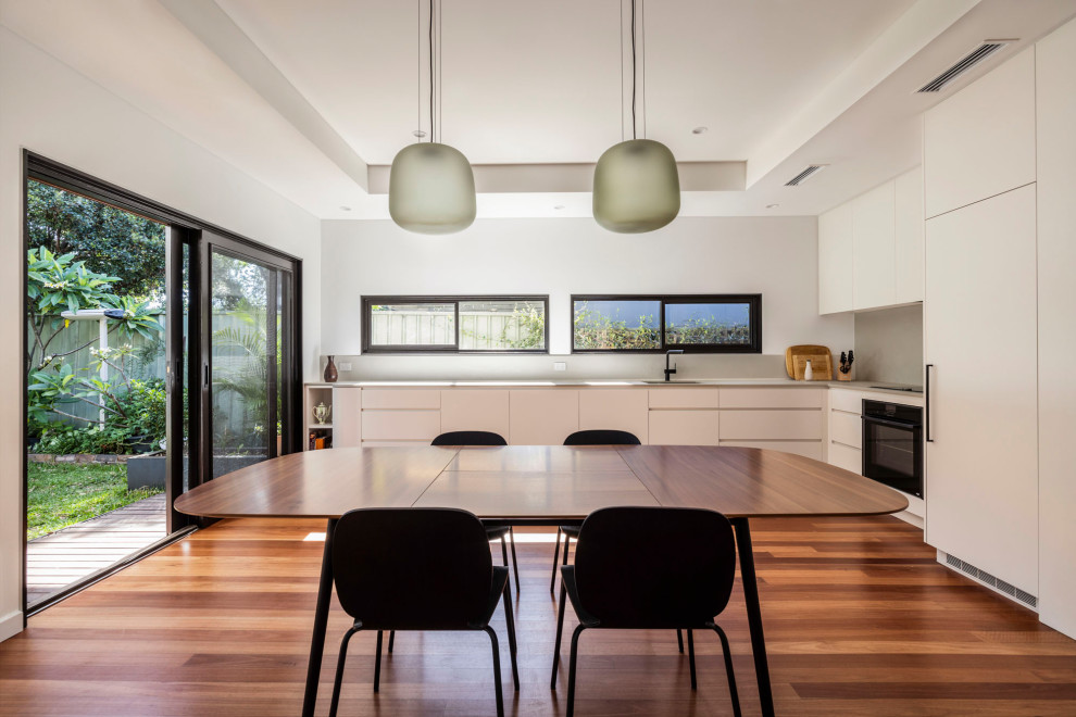 Offenes, Mittelgroßes Modernes Esszimmer mit weißer Wandfarbe, braunem Holzboden und braunem Boden in Sydney