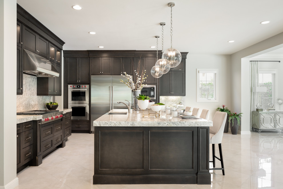Eat-in kitchen - transitional beige floor eat-in kitchen idea in Orange County with dark wood cabinets, stainless steel appliances and an island