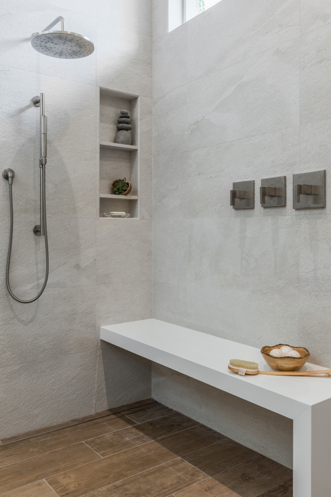 Foto på ett stort vintage vit en-suite badrum, med släta luckor, grå skåp, ett fristående badkar, en kantlös dusch, en bidé, grå kakel, porslinskakel, beige väggar, klinkergolv i porslin, ett undermonterad handfat, bänkskiva i kvarts, brunt golv och med dusch som är öppen