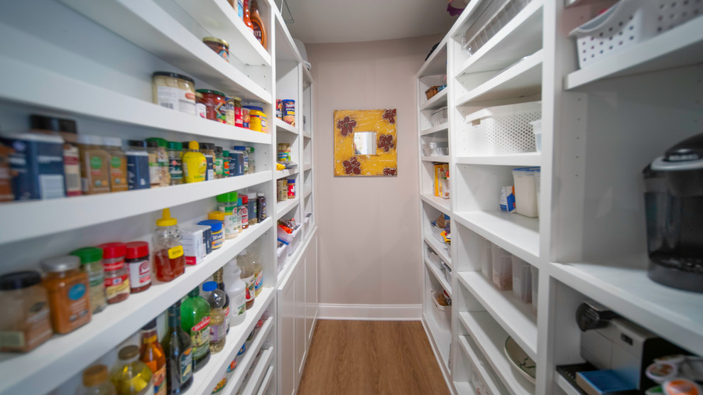 Large minimalist l-shaped medium tone wood floor and brown floor kitchen pantry photo with an undermount sink, recessed-panel cabinets, white cabinets, solid surface countertops, gray backsplash, stainless steel appliances, two islands and multicolored countertops