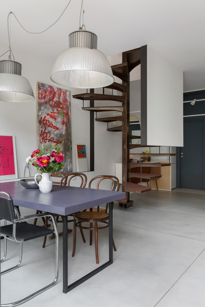 Inspiration for an industrial dining room in Milan with concrete floors and grey floor.