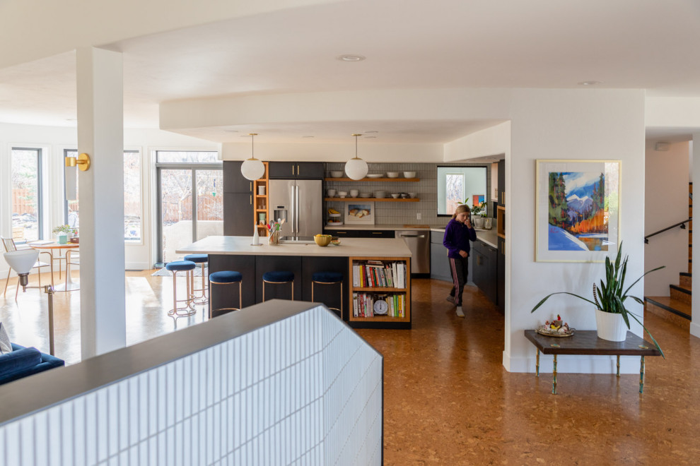 Photo of a mid-sized contemporary eat-in kitchen in Denver with a drop-in sink, flat-panel cabinets, blue cabinets, concrete benchtops, white splashback, subway tile splashback, stainless steel appliances, cork floors, with island, brown floor and white benchtop.