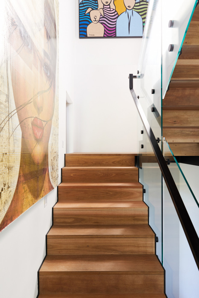 Cette image montre un grand escalier urbain en U avec des marches en bois, des contremarches en bois et un garde-corps en métal.