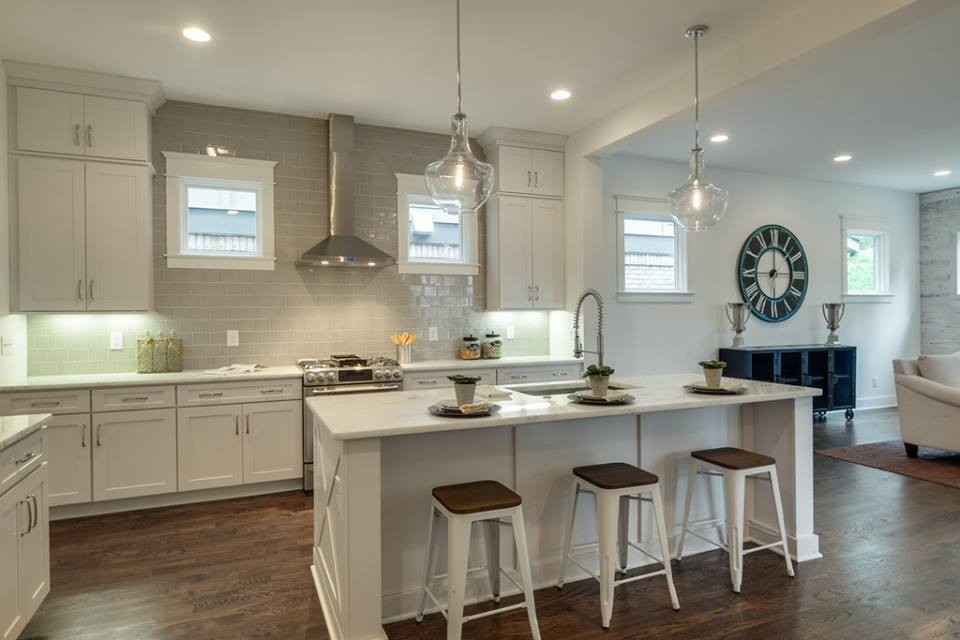 This is an example of a large transitional galley eat-in kitchen in Nashville with a single-bowl sink, shaker cabinets, white cabinets, quartzite benchtops, grey splashback, subway tile splashback, stainless steel appliances, dark hardwood floors and with island.