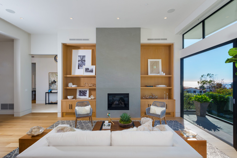 This is an example of a large contemporary open concept living room in Los Angeles with white walls, light hardwood floors, a ribbon fireplace and a stone fireplace surround.