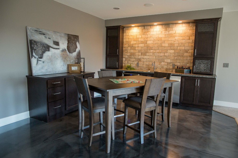 Mid-sized transitional single-wall seated home bar in Minneapolis with a drop-in sink, shaker cabinets, dark wood cabinets, laminate benchtops, beige splashback, brick splashback and concrete floors.