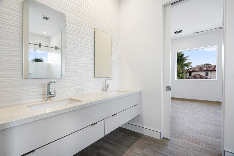 Inspiration for a large modern kids bathroom in Other with white cabinets, a freestanding tub, a one-piece toilet, white tile, white walls, ceramic floors, a vessel sink, beige floor, a hinged shower door and grey benchtops.