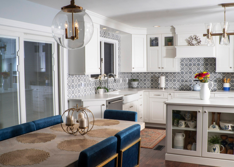 Mid-sized transitional l-shaped medium tone wood floor and brown floor eat-in kitchen photo in St Louis with a farmhouse sink, recessed-panel cabinets, white cabinets, quartz countertops, blue backsplash, ceramic backsplash, stainless steel appliances, an island and white countertops