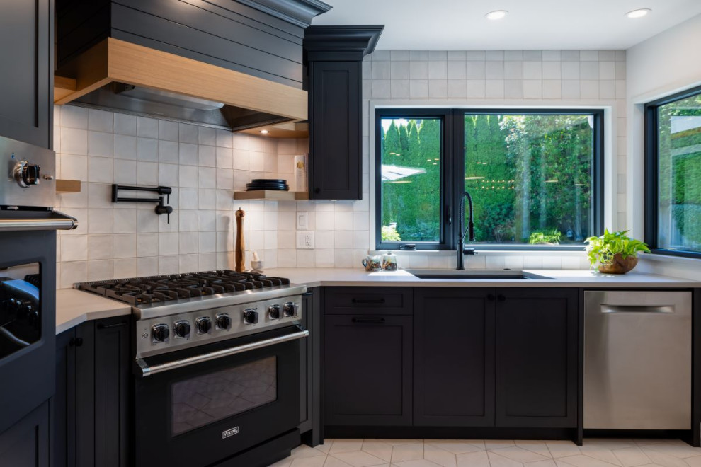 Inspiration for a mid-sized transitional u-shaped porcelain tile and white floor open concept kitchen remodel in Vancouver with an undermount sink, shaker cabinets, gray cabinets, granite countertops, white backsplash, porcelain backsplash, stainless steel appliances, a peninsula and black countertops